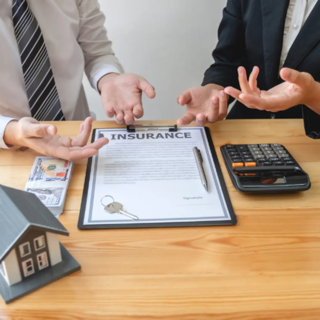 A real estate agent with House model is talking to clients about buying home insurance. Home insurance concept.